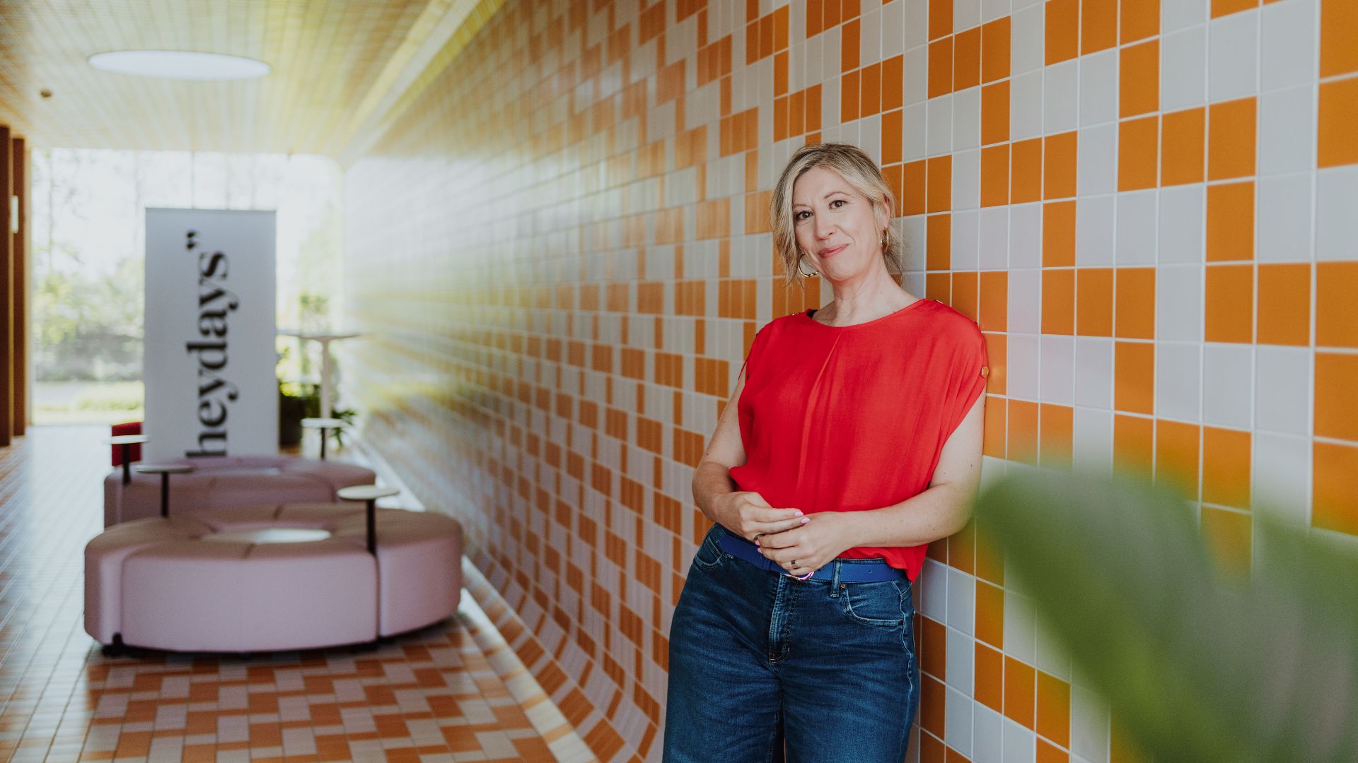 Elke Van Parys in het pand van heydays aan de oranje tegelwand