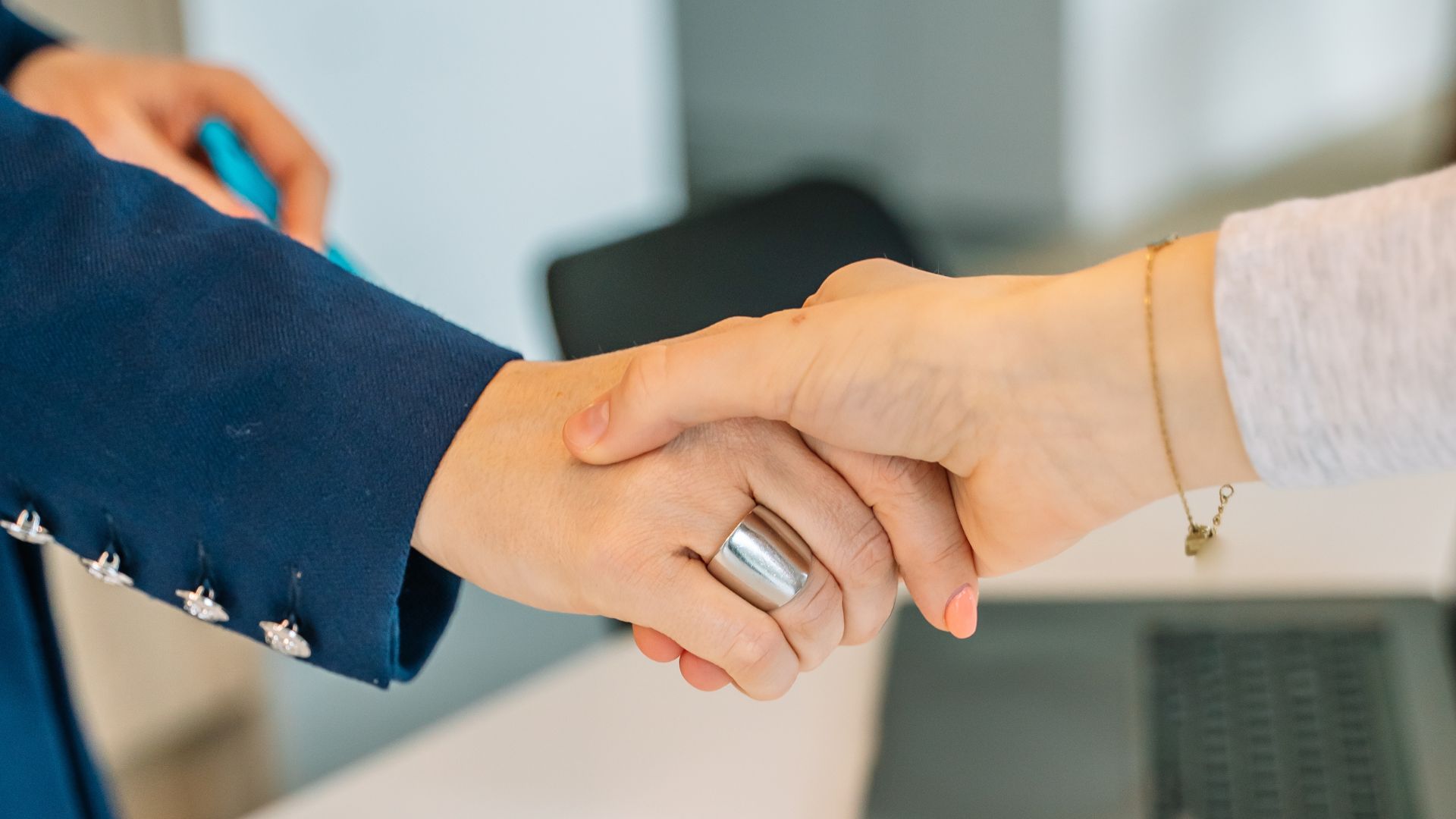 Twee collega's schudden elkaar de hand na een succesvol gesprek over delegeren