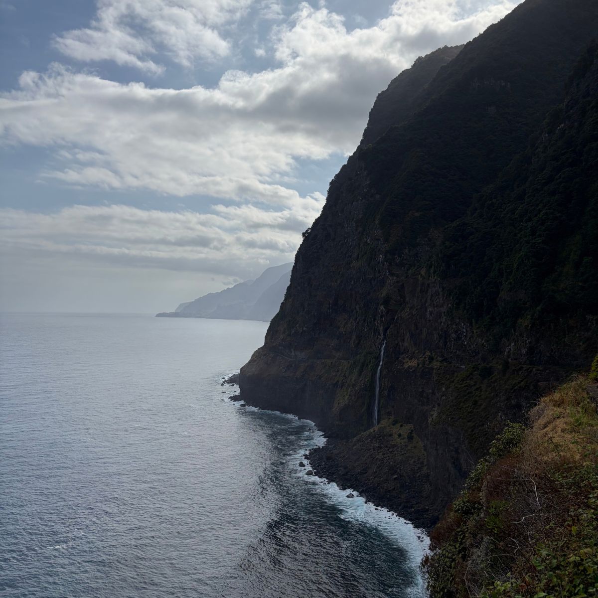 Kustklif met een dunne waterval die naar zee stroomt op Madeira