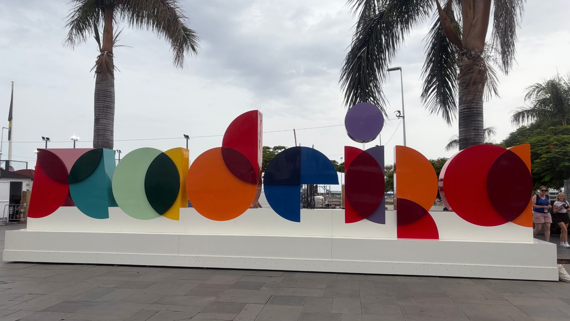 Kleurrijk letterteken met het woord Madeira op een plein in Funchal, met palmbomen erachter