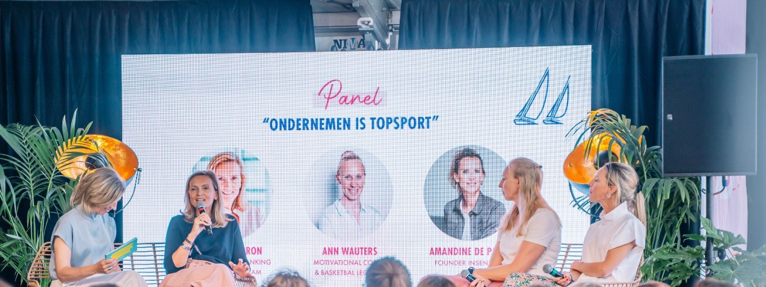 Elke Van Parys interviewt een panel tijdens het panelgesprek Ondernemen is topsport