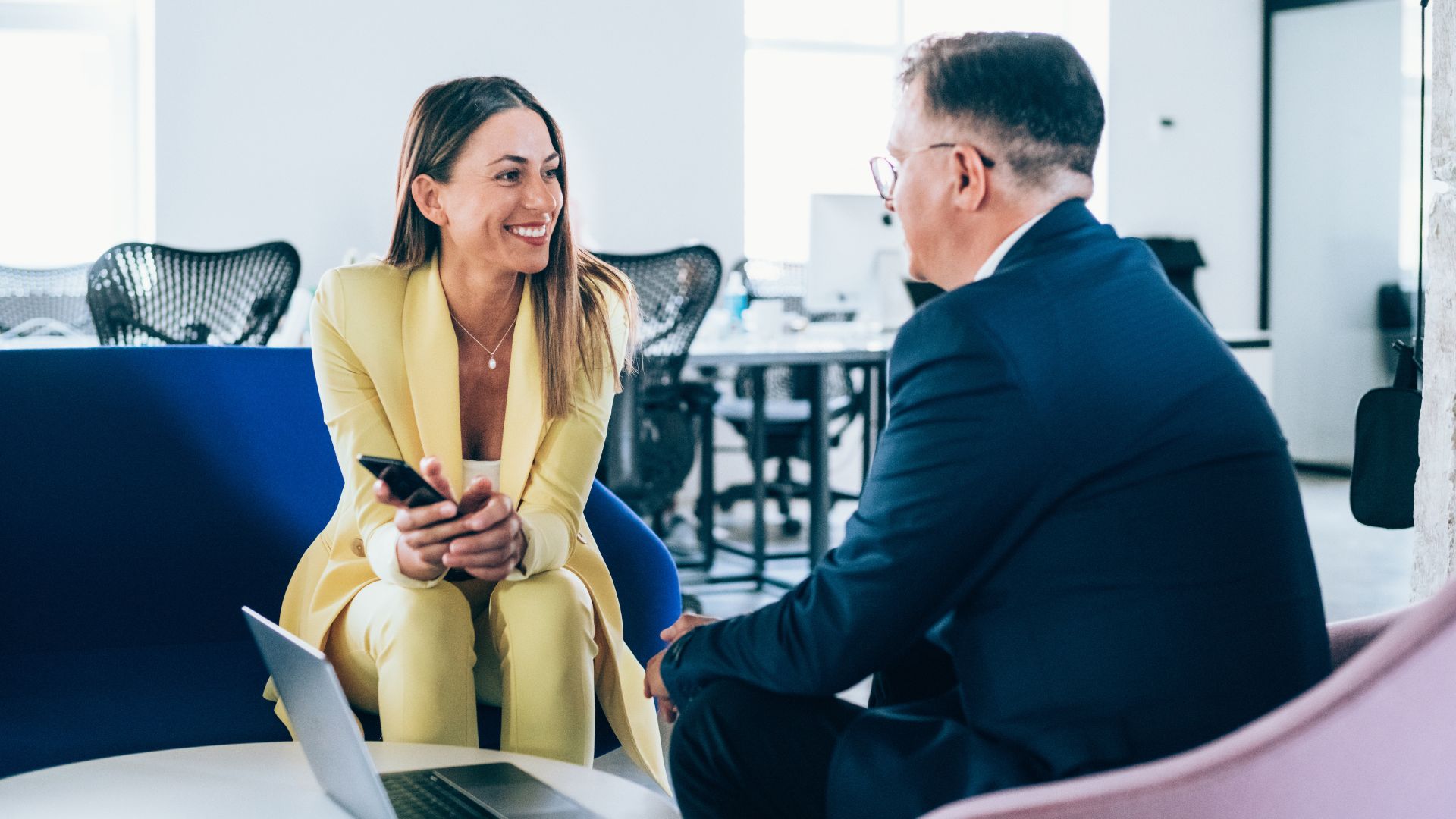 Twee professionals in gesprek in een moderne kantooromgeving tijdens een workshop verbindend communiceren