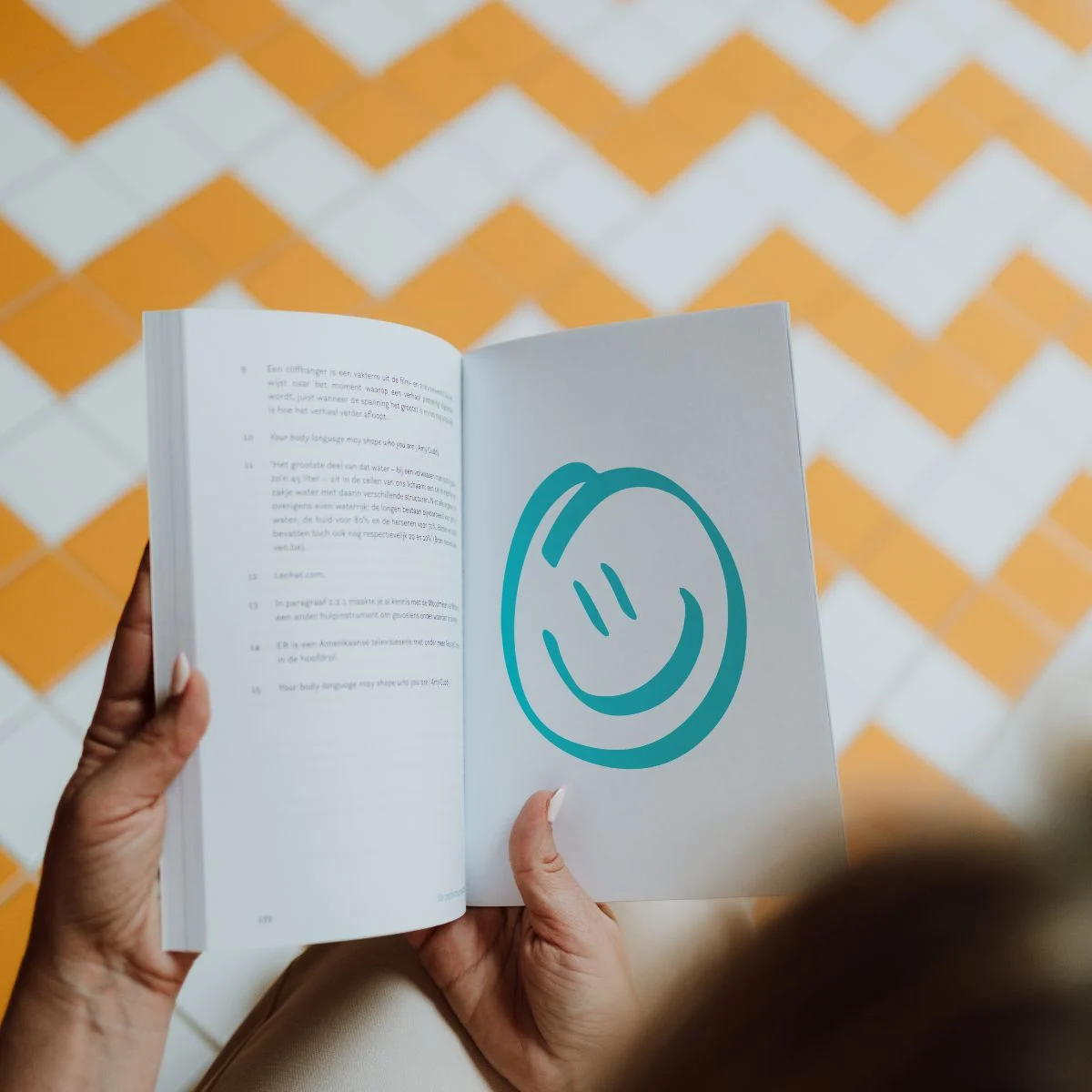 Een opengeslagen boek met communicatietips en een turquoise glimlach