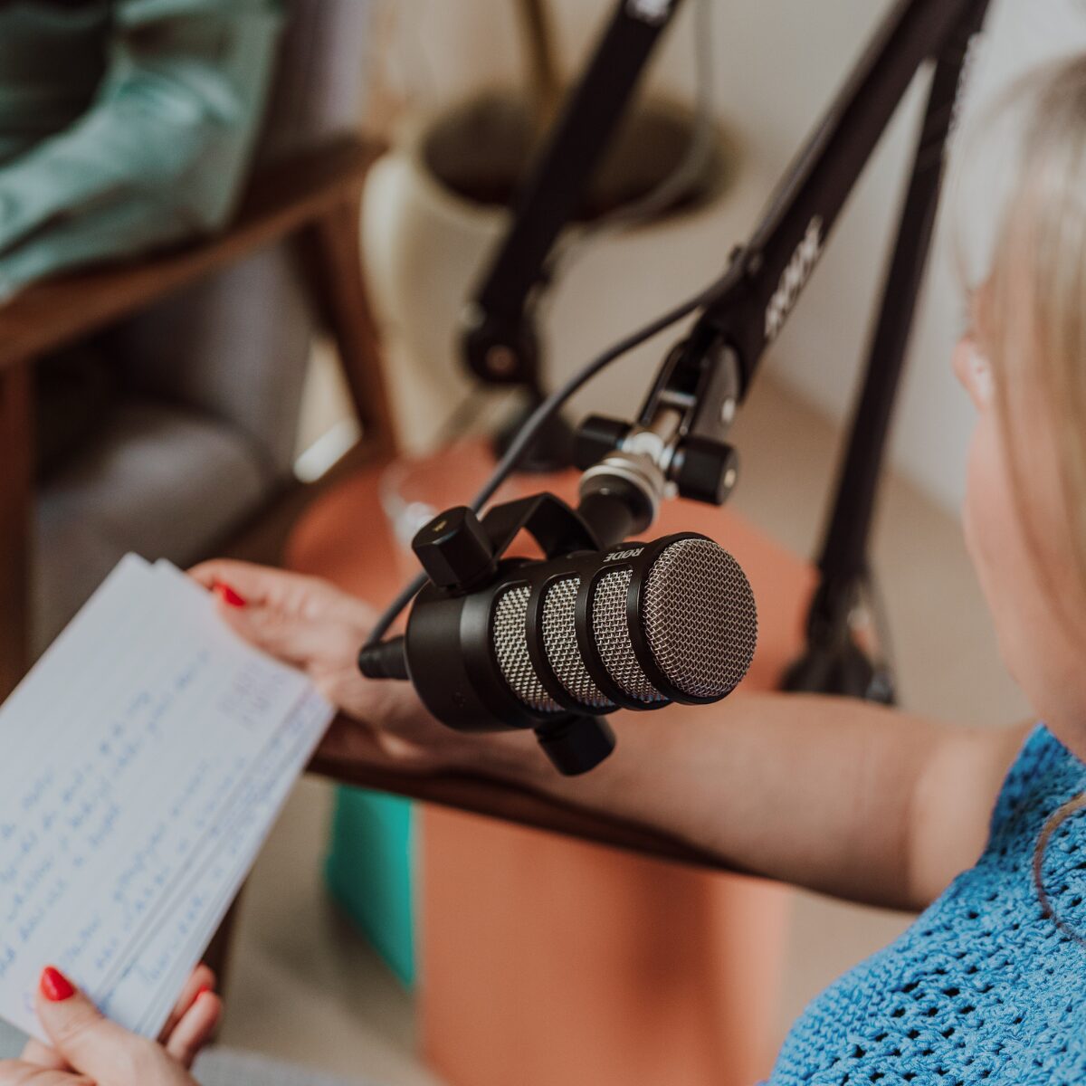 Elke Van Parys leest haar notities bij de RØDE-microfoon in de podcaststudio