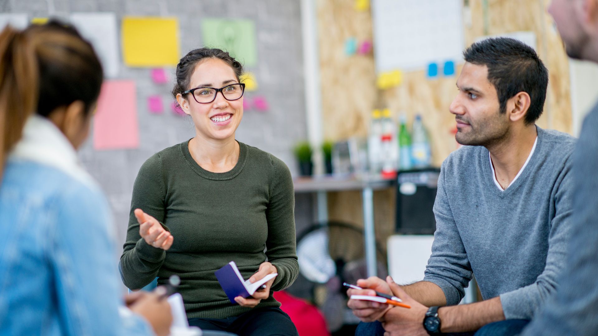 Een groep professionals in gesprek tijdens een intervisiesessie in een moderne kantooromgeving