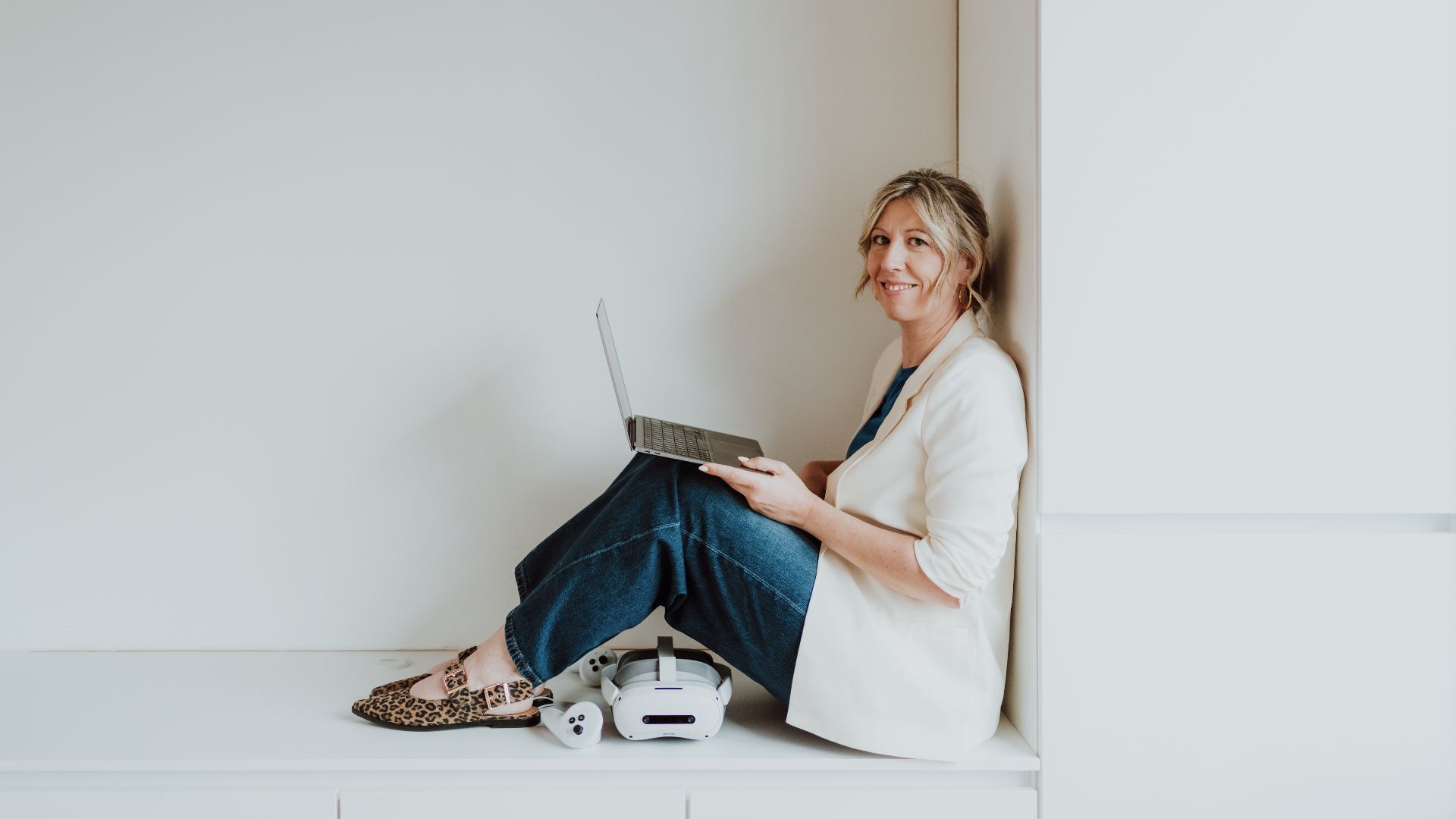 Elke Van Parys met laptop en VR-bril in een lichte ruimte