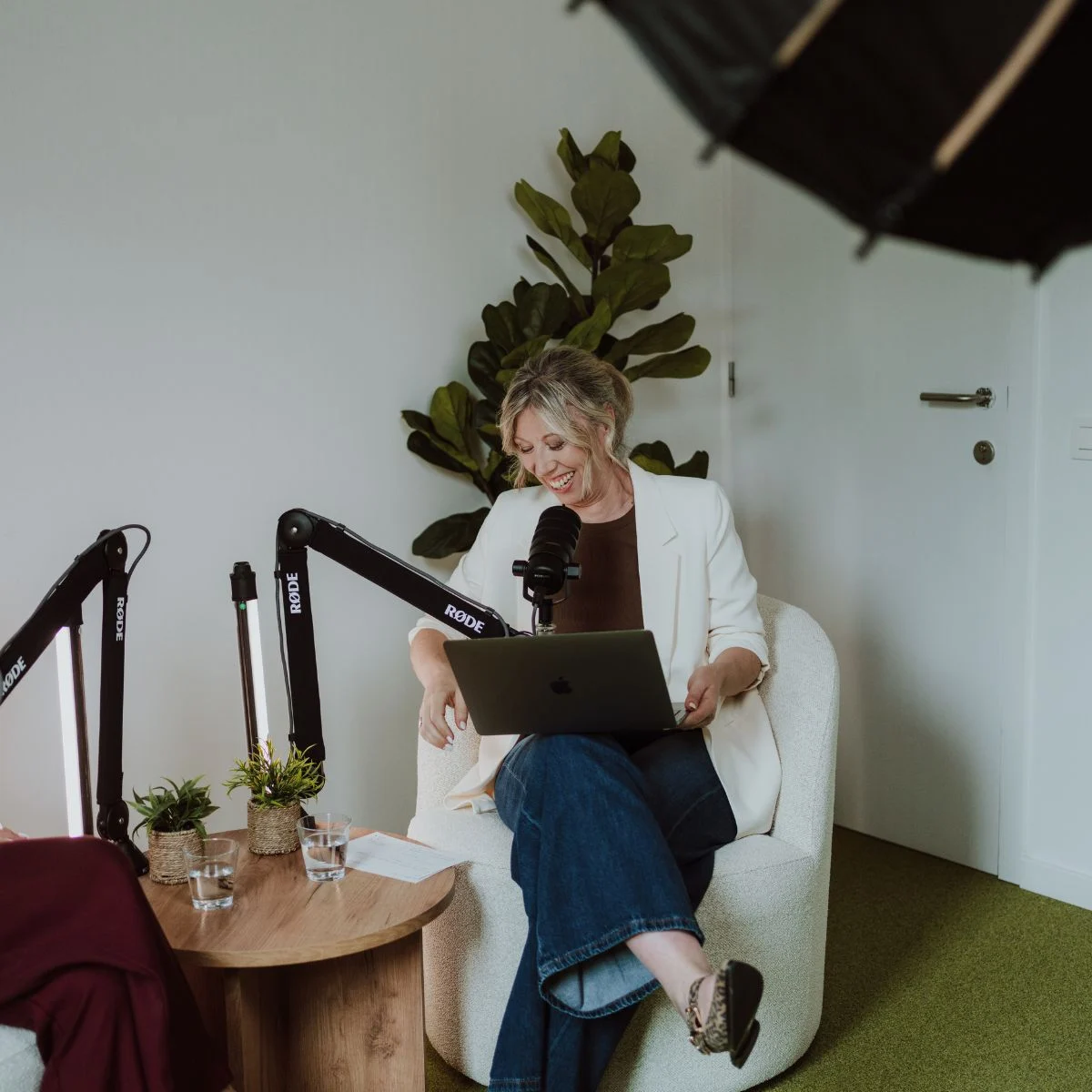 Elke Van Parys bereidt een podcastopname voor met een laptop en microfoon